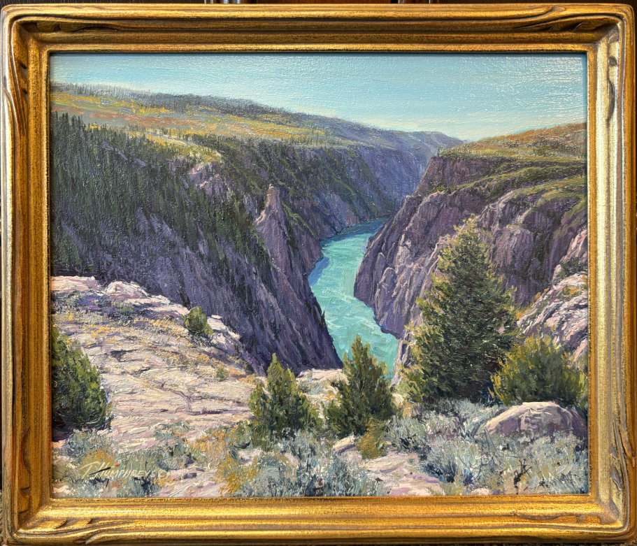 A serene landscape featuring a river winding through rocky canyons and green trees.