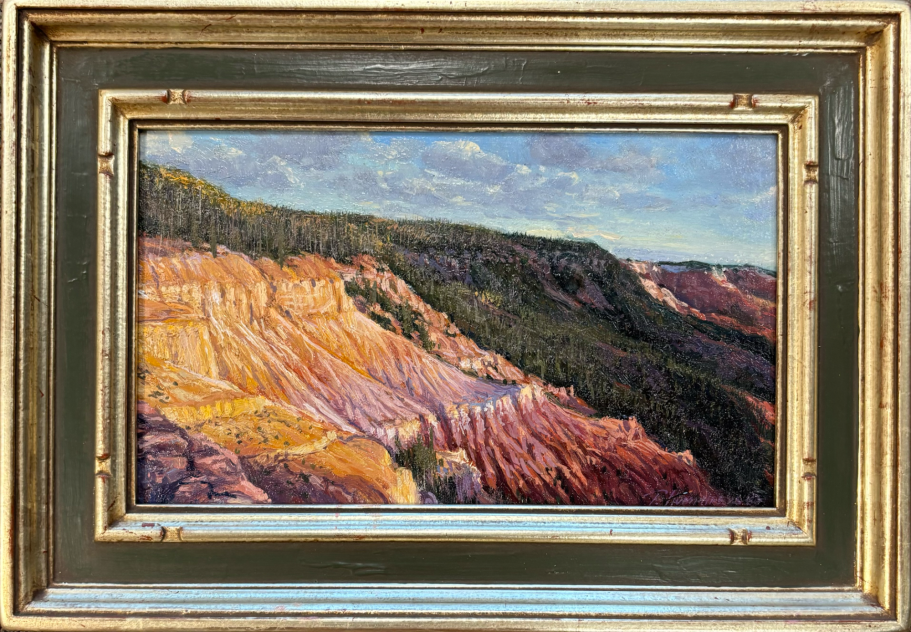 Landscape featuring colorful rock formations and distant hills under a cloudy sky.
